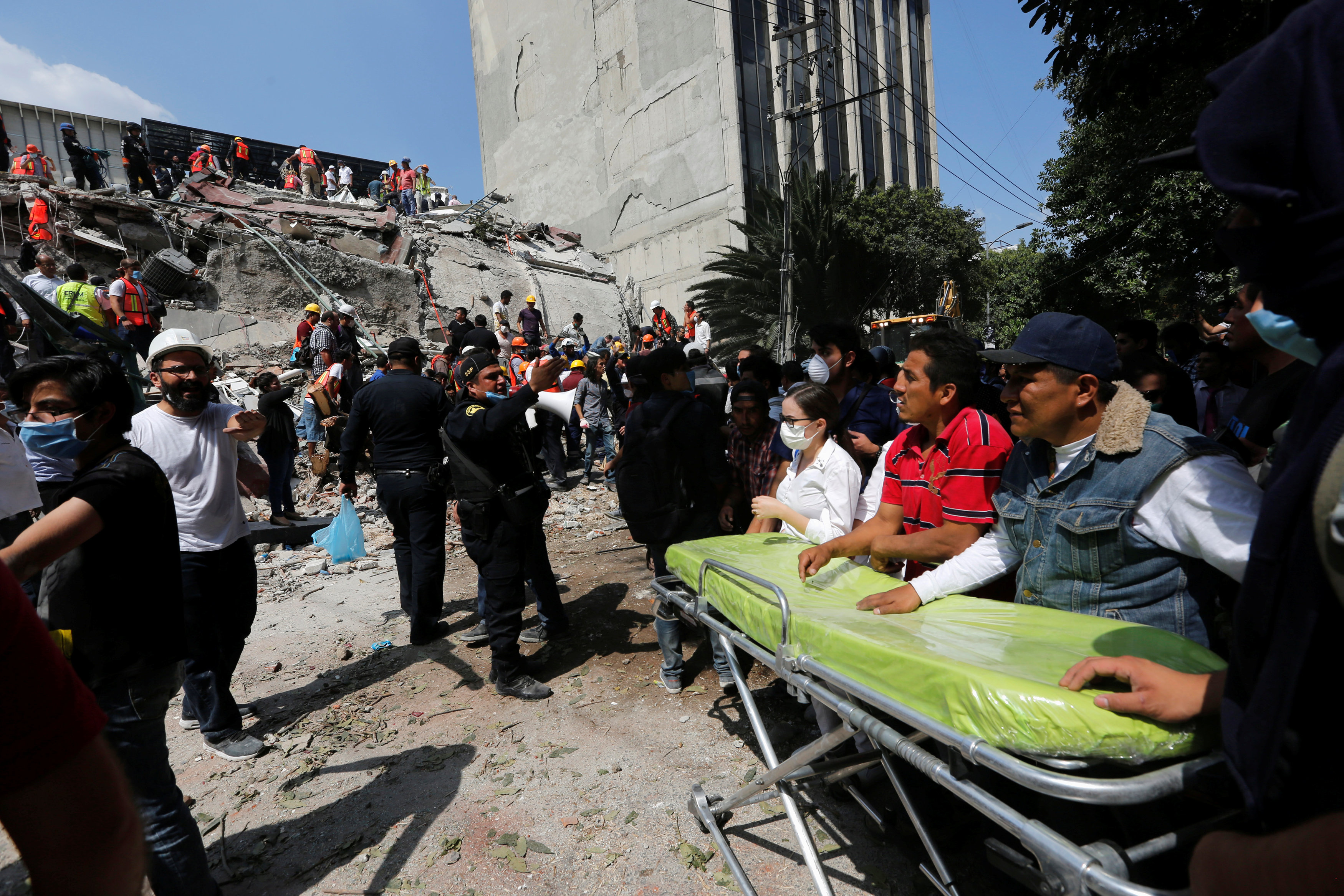 Paramedics wait as rescue personnel search for people in the rubble of a collapsed building after an earthquake hit Mexico City, Mexico